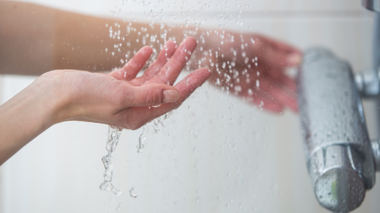 woman in the shower testing the temperature of the water