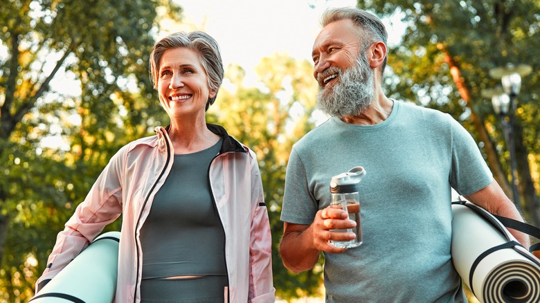 couple going to yoga outside with mats