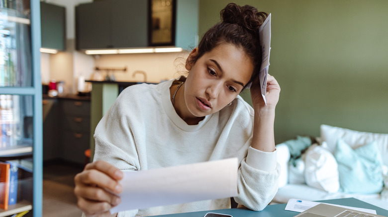 Overwhelmed woman reading mail