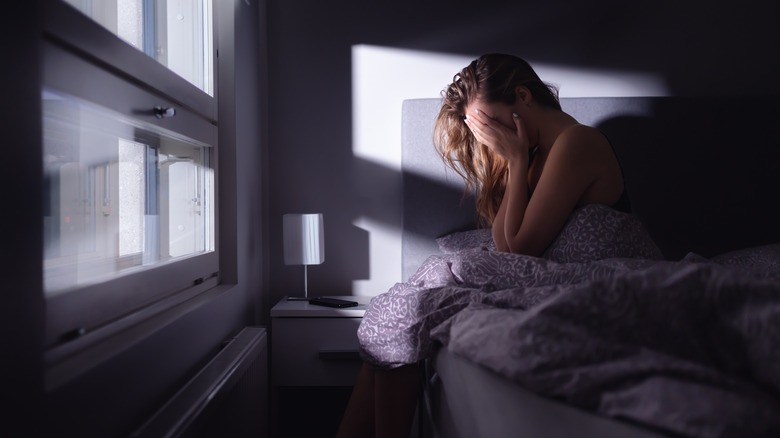 woman sitting in bed stressed out