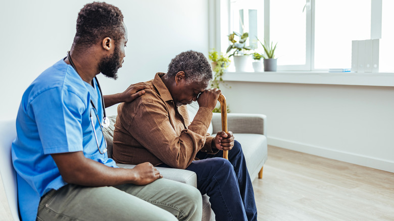 Healthcare professional comforting older man