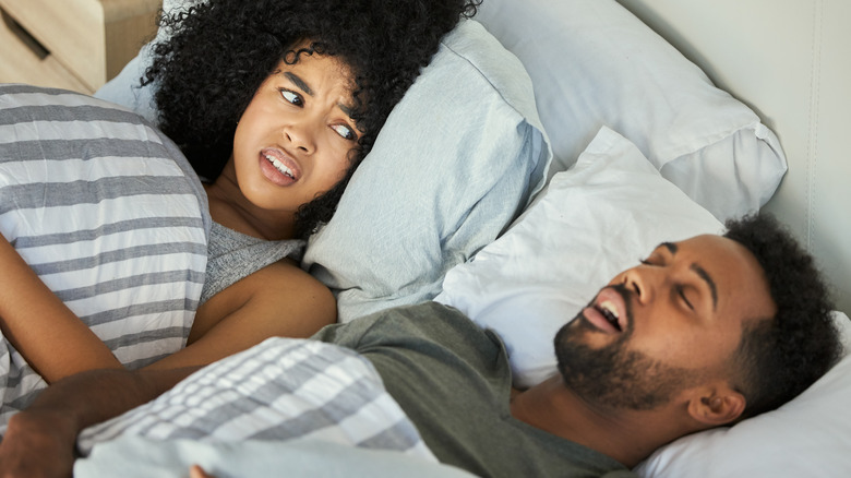 woman awake while her husband snores