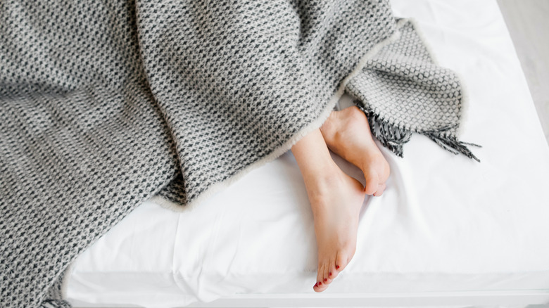 Woman's feet under blanket