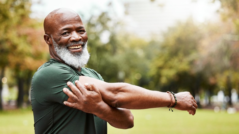 smiling older man exercising outdoors