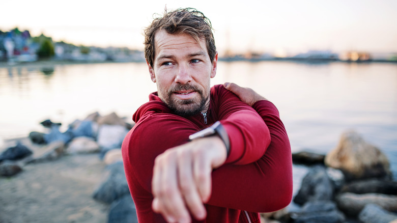 midlife man stretching shoulder before exercise