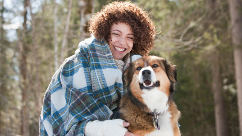 woman bundle up outside with dog