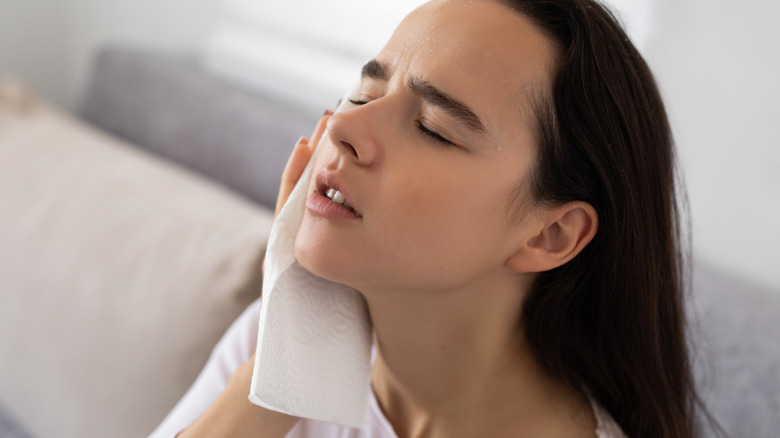 Person wiping face with water to cool down