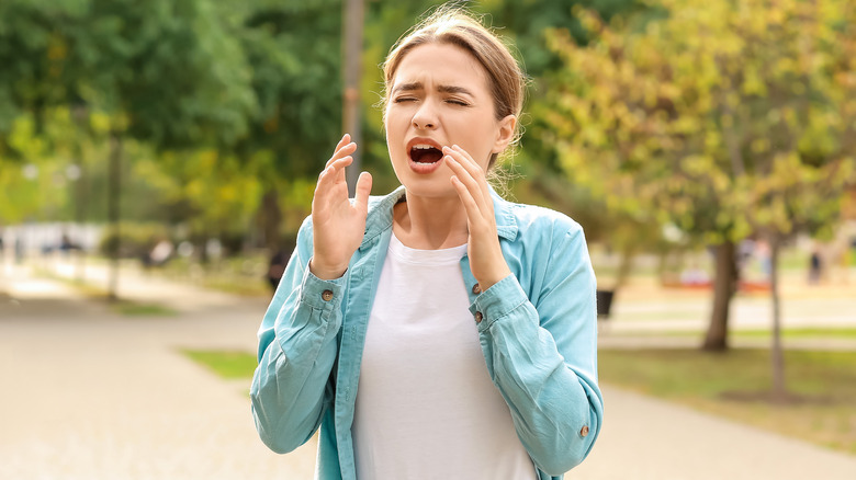 Individual coughing during walk in park