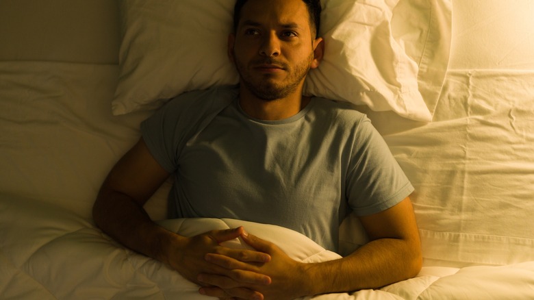 Man laying in bed awake