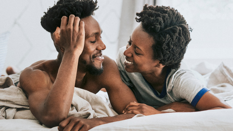 smiling and happy man and woman in bed