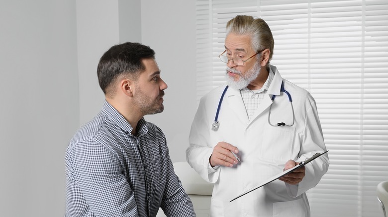 A man in his 30s talking to a doctor