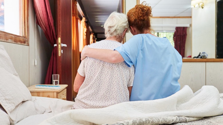 Woman comforting old lady