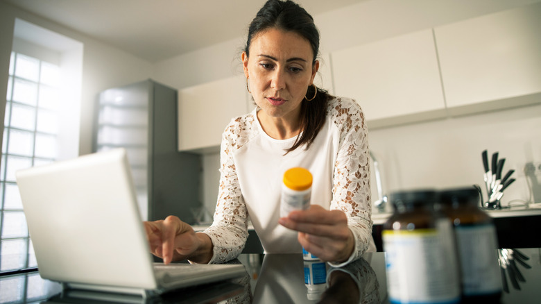 woman reading a medication bottle