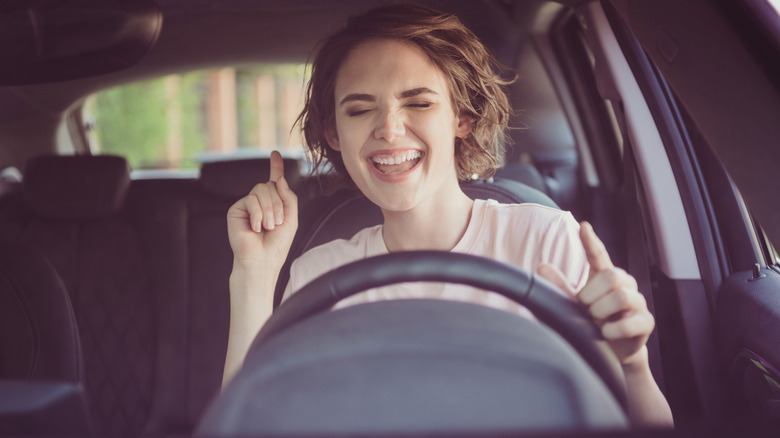 Young woman dancing in car