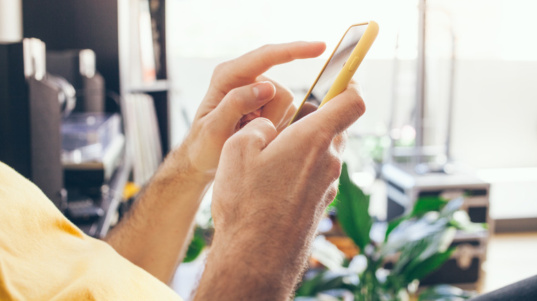 Hands typing on phone