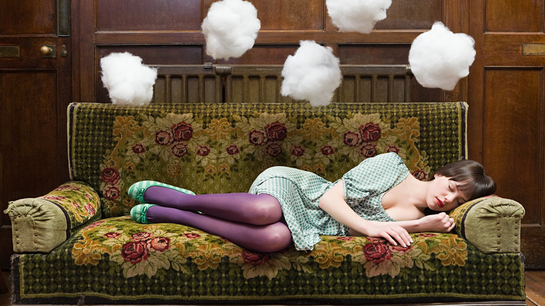 woman sleeping on a couch with cotton balls floating over her