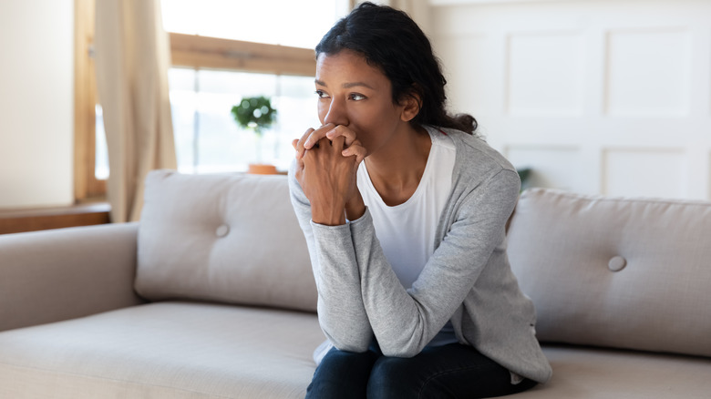 Sad woman sitting on couch