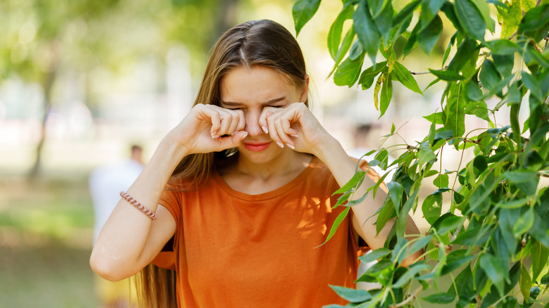 Teen rubbing eyes