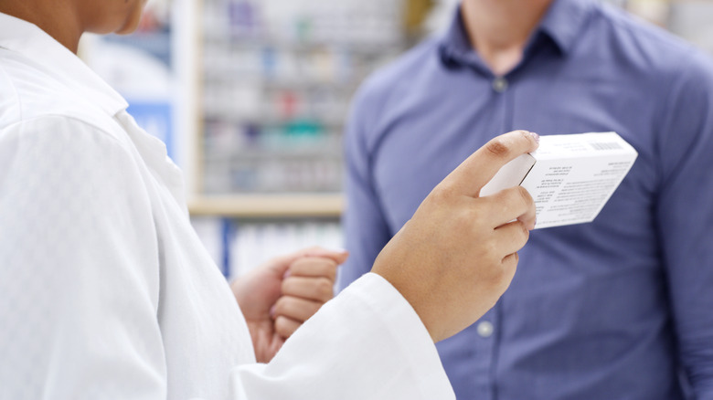 Pharmacist holding up prescription