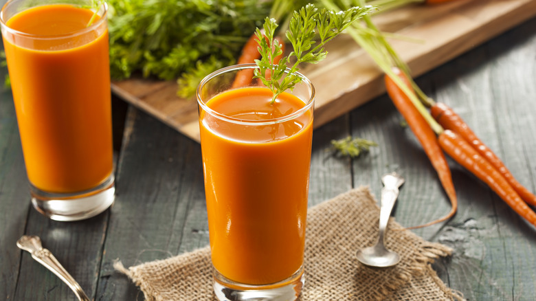 carrot juice next to fresh carrots 