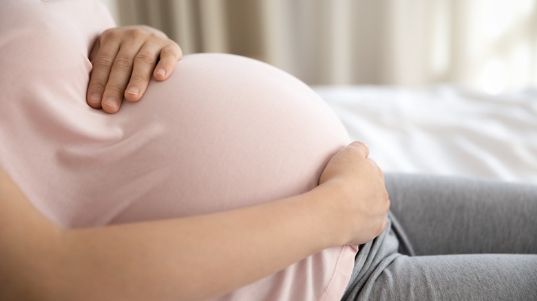 woman holding pregnant stomach