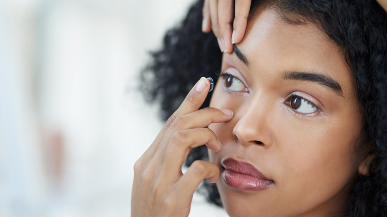 Woman putting in contact lens