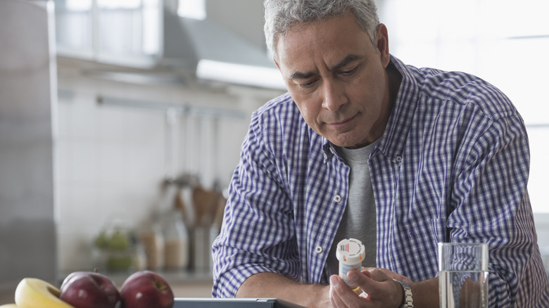 midlife man looking at prescription bottle