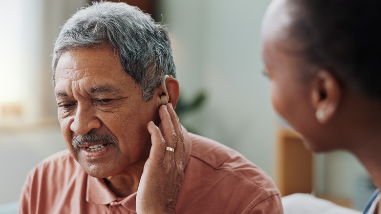 senior man with ear problems at doctor's appointment