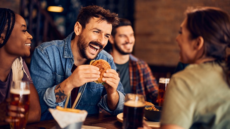 Man with friends eating a burger