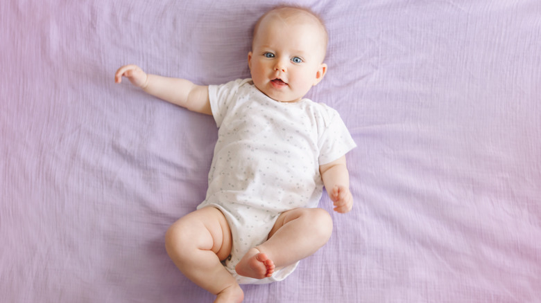 Baby awake on violet blanket