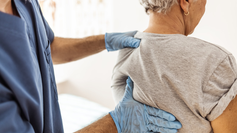 Doctor hands examining patient's back