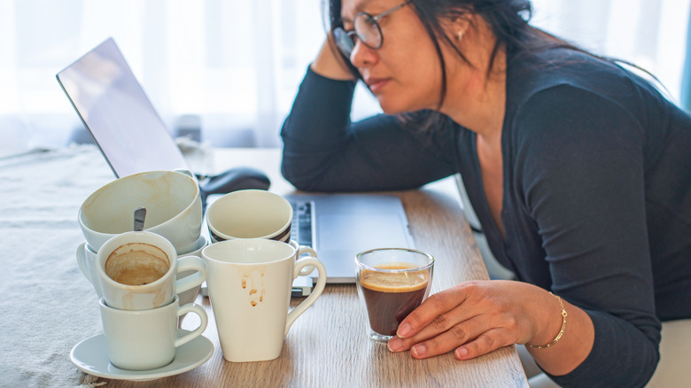 Woman drinking coffee at her laptop