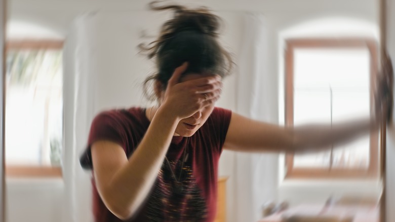 Dizzy woman holding wall