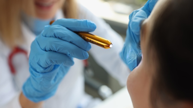 Doctor using flashlight in patient's eye