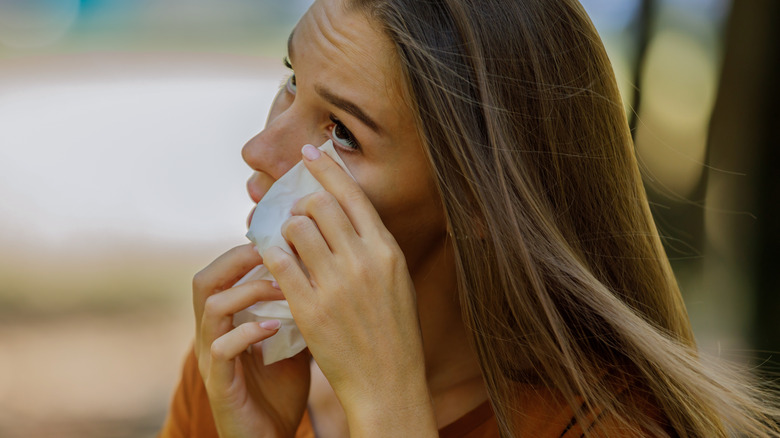 Woman blotting her eye with a tissue