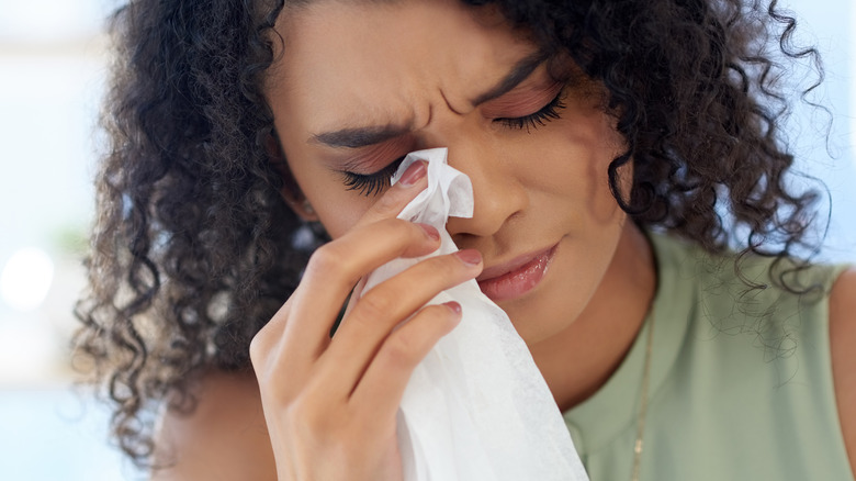 Woman blotting her eyes with a tissue