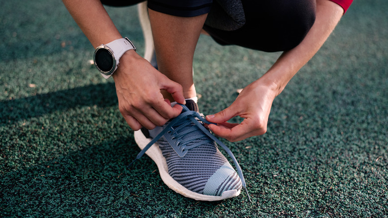 woman putting on athletic shoes