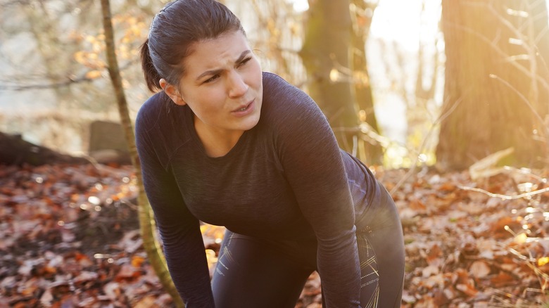 Woman catching breath exercising outdoors