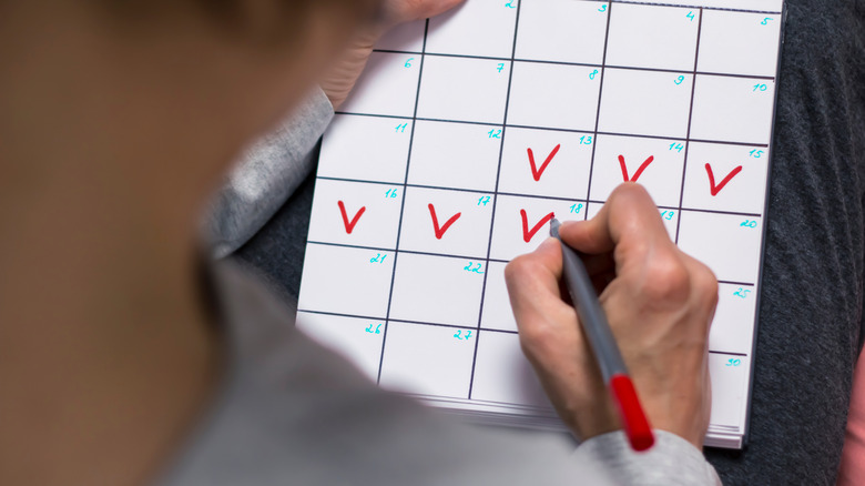 A woman marks the days of menstruation in her calendar.