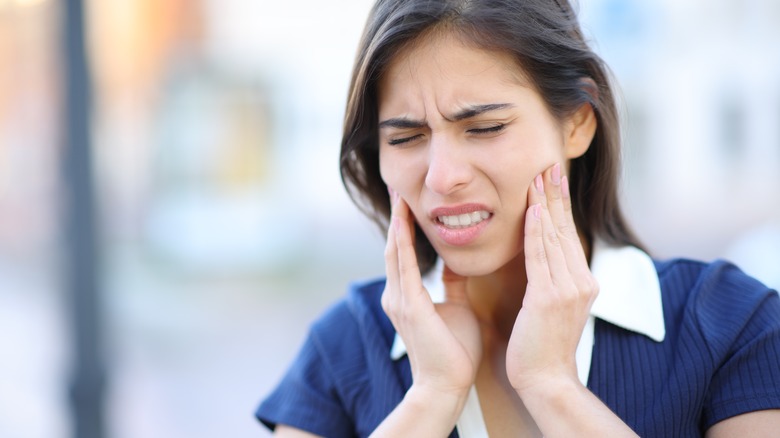 Woman in pain holding jaw