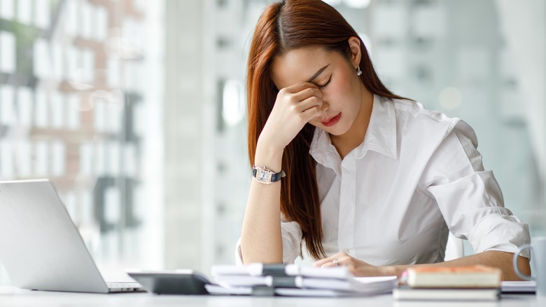 Woman looking stressed at desk