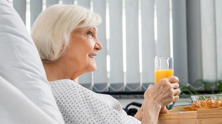 elderly woman patient holding orange juice