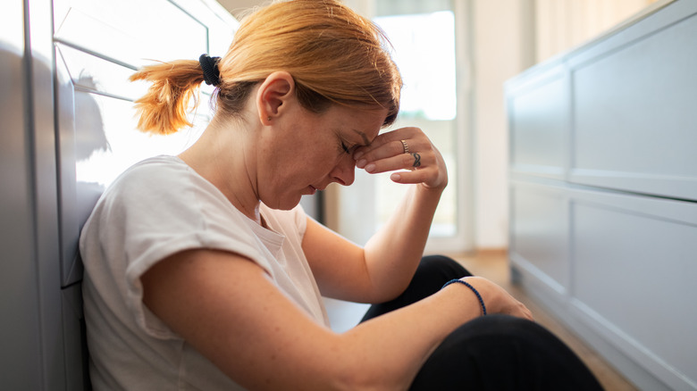 Stressed woman pinching bridge of nose