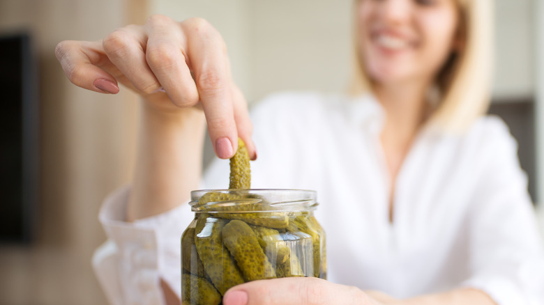 woman eating pickles from a jar