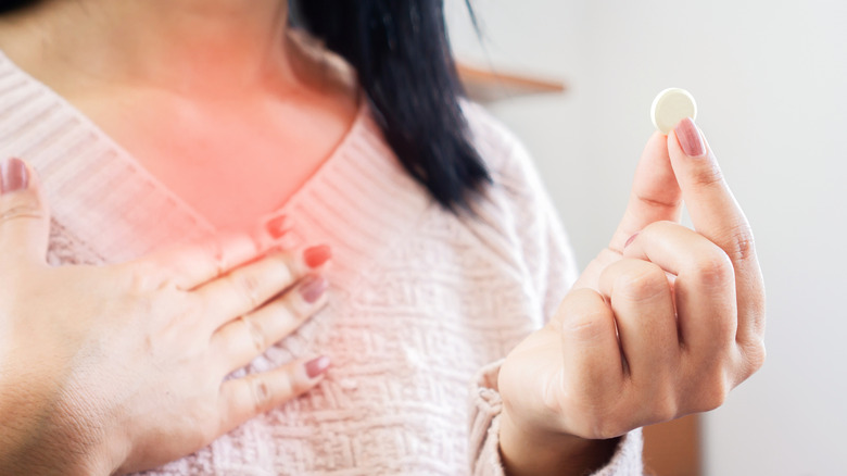 Woman with heartburn taking antacid 