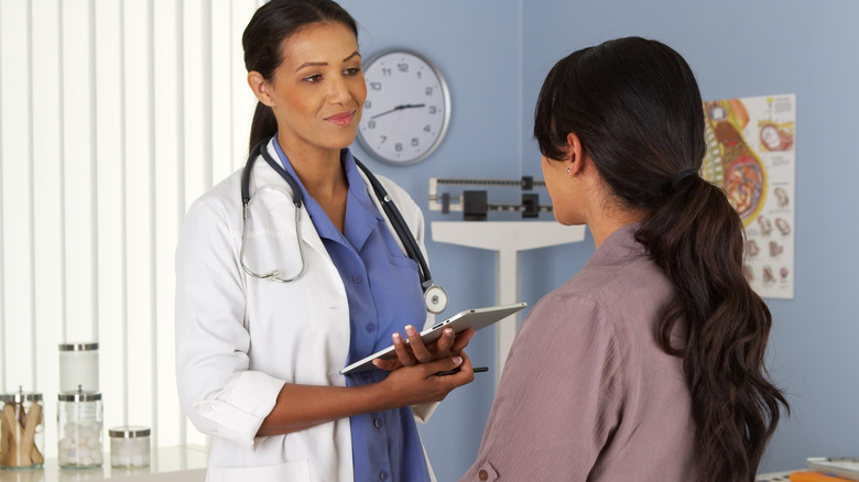 Young woman talking to OBGYN in doctor's office