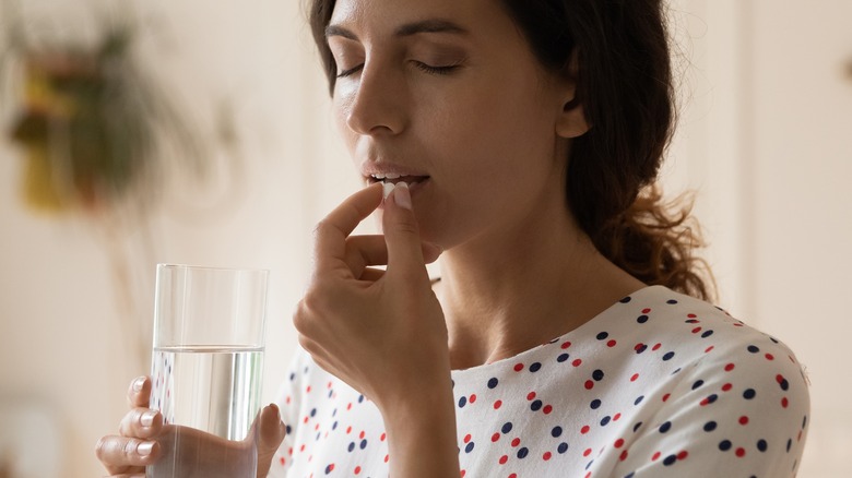 Woman taking medication with water