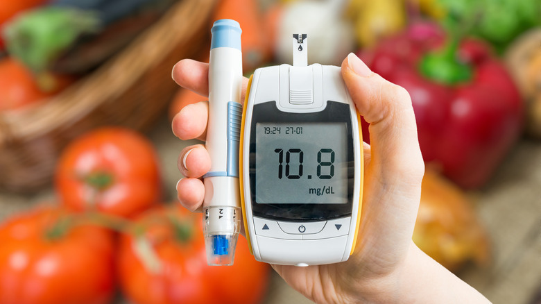 Close up of glucometer with vegetables in background