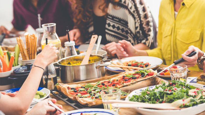 Friends at a party eating a lot of different foods.