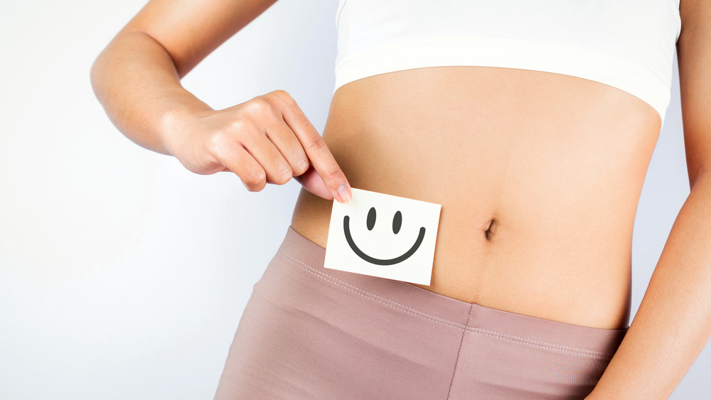 Woman holding white card with smiley face 